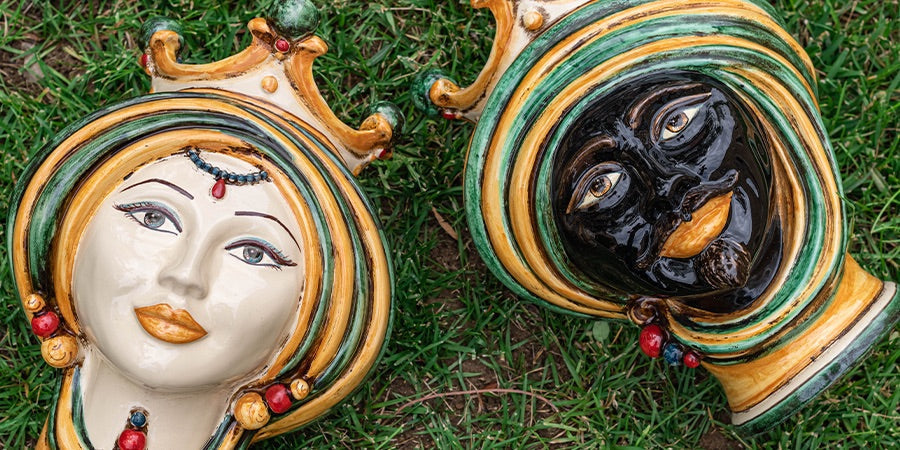 Teste di moro ceramiche Caltagirone fatti a mano su prato, artigianato siciliano