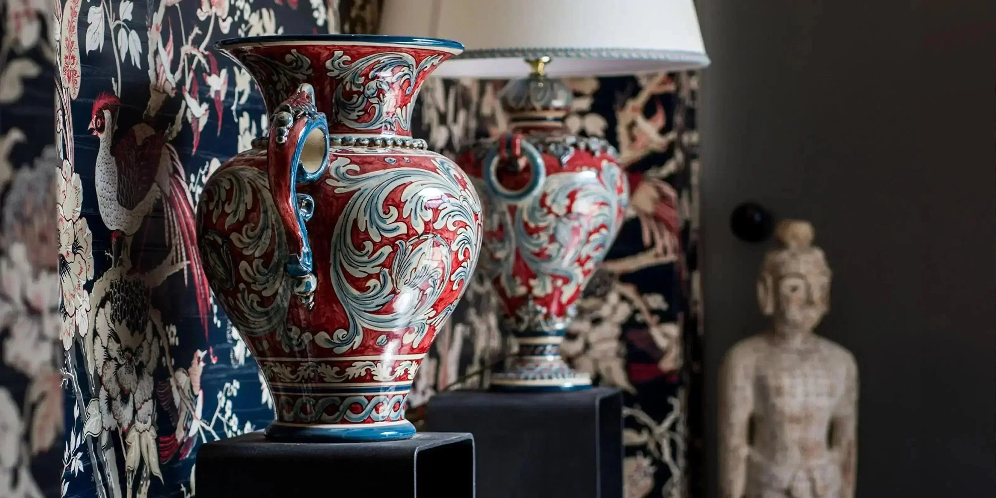 Vasi ornati blu e bordeaux con dettagli floreali su piedistalli, ceramiche Caltagirone fatti a mano