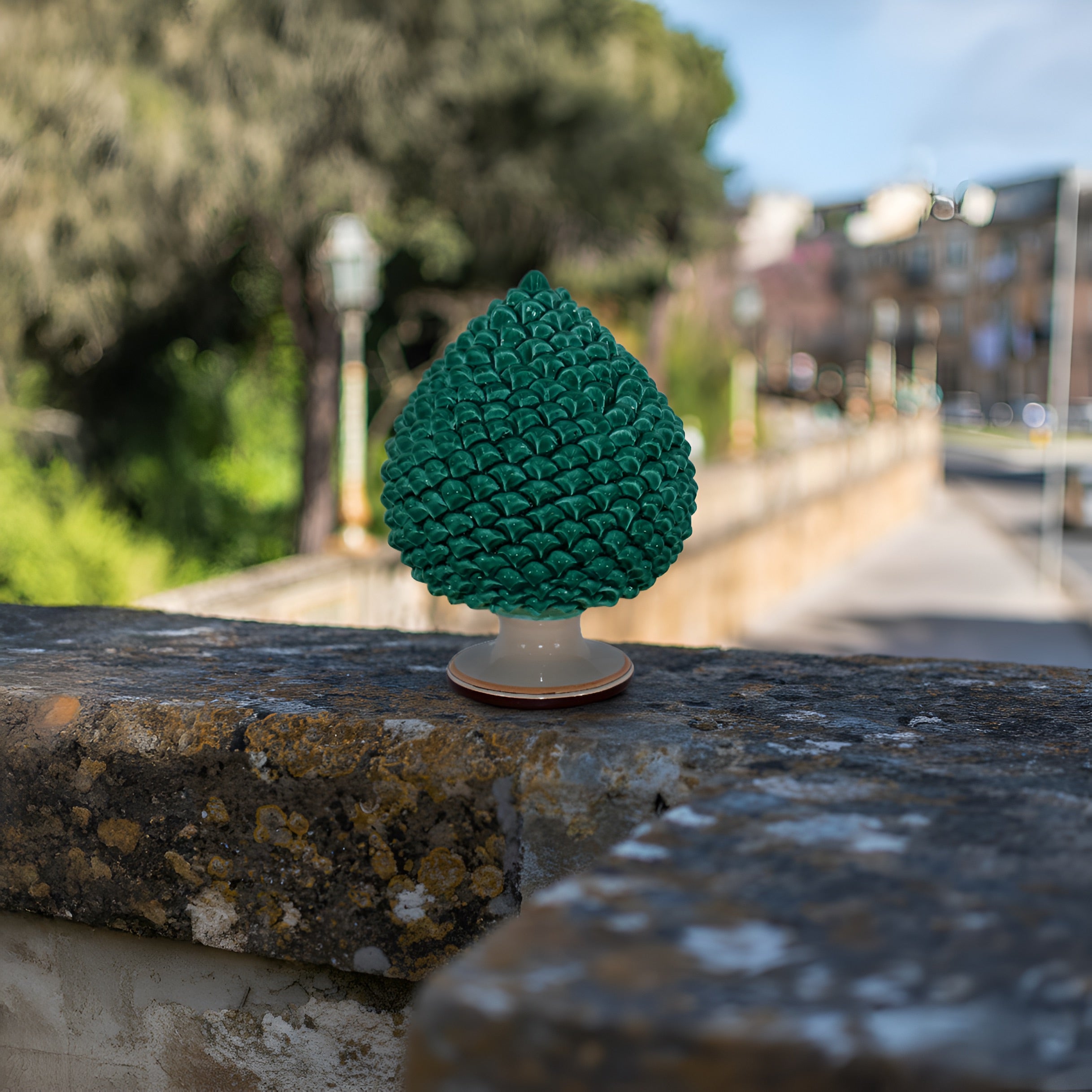 Pigna verde in ceramica di Caltagirone fatti a mano su muretto, ambiente urbano