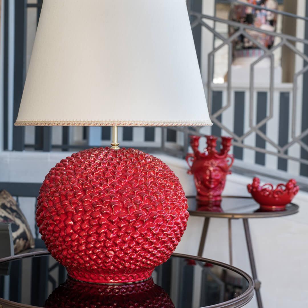 Lume palla a pigna rosso fuoco ceramiche Caltagirone fatti a mano, design artigianale elegante.