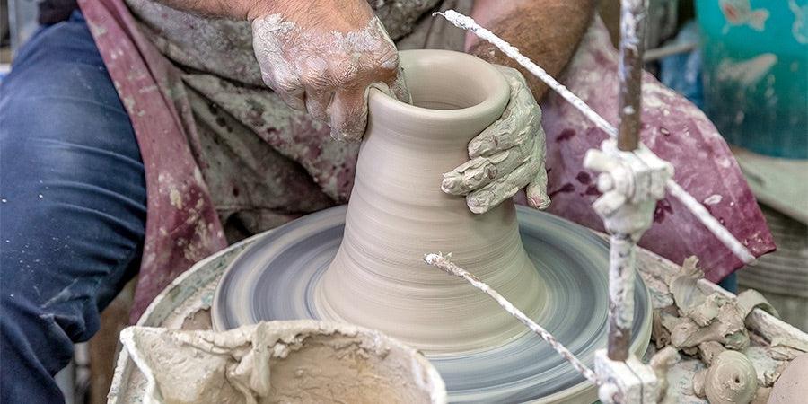 artigiano che modella vaso in ceramica su tornio con ceramiche caltagirone fatti a mano